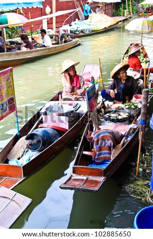 BANGKOK  MARCH 18: Wooden boats busy ferrying people at Amphawa floating market on March 18, 2012 in Bangkok. A traditional popular method of buying and selling still practiced in Amphawa Thailand.