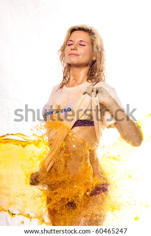 Beautiful sexual wet girl in white shirt in the drops of water. Girl watering fountain of yellow water