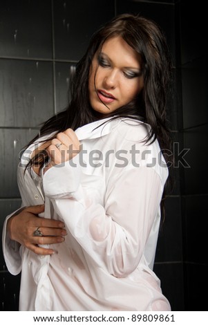 Beautiful sexual wet girl in white shirt with expressive eyes in the drops of water