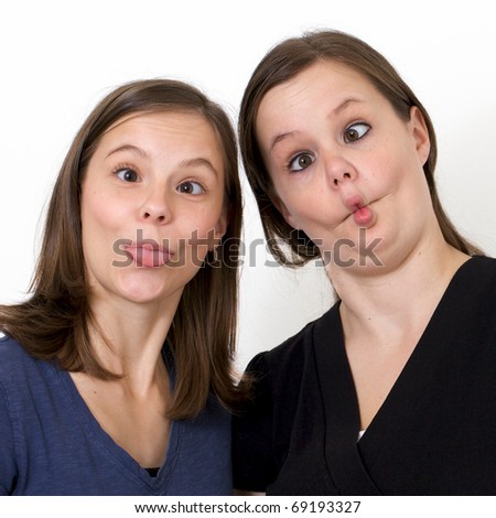 Sisters looking silly while goofing around with crossed eyes and puckered lips