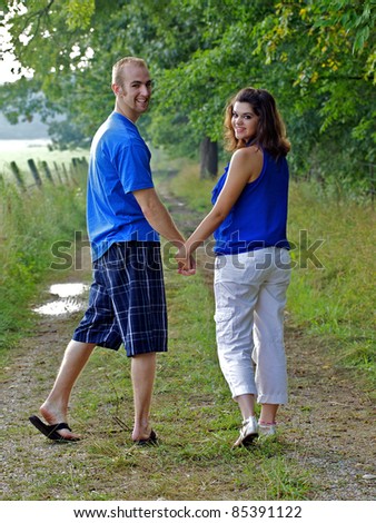 Couple holding hands looking back at photographer