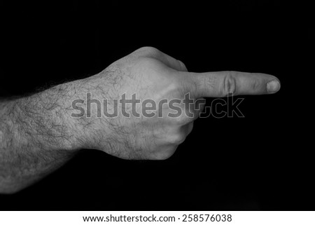 Black and white image of a hand pointing to the right with a black background