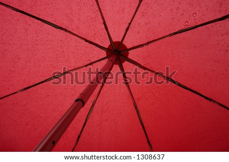 Close up of the underside of a red umbrella in the rain. Abstract graphic image, suitable for background.