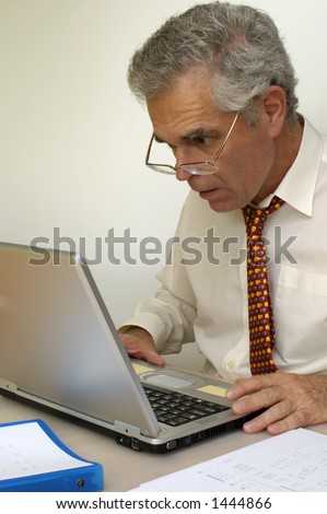 A businessman looking intently at his laptop computer. What is going on on the screen?