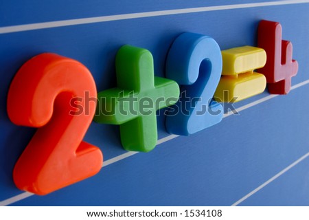 A simple equation, from a child\'s toy number set, looms large and intimidating. Is this what a sum looks like to a child having difficulty with maths? Focus on the plus sign.