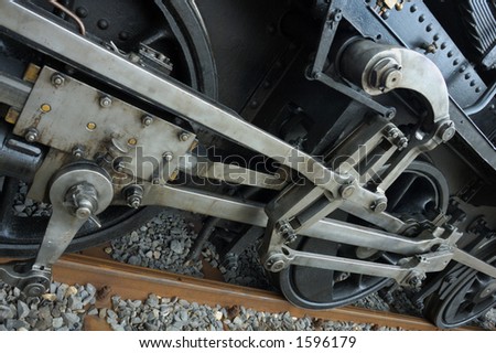 Detail of the driving gear of an old steam engine as it stands in a station.