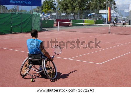 A wheelchair tennis player during a tennis championship match, preparing to take a shot.