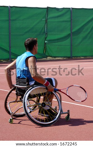 A wheelchair tennis player during a tennis championship match, waiting to take a shot.