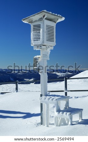 An ice-covered Stevenson Screen weather station, high on a mountain-top in Switzerland