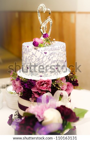 Wedding cake with silver heart topper and purple flowers