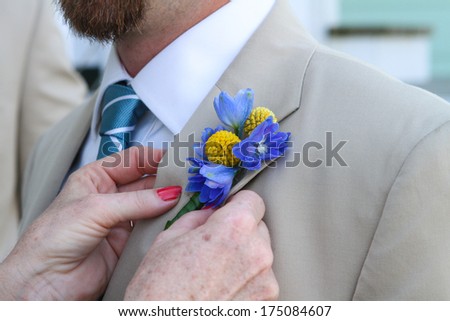 Men\'s suit up close, pinning flowers