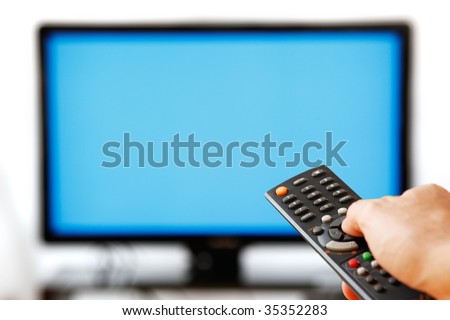 Out of focus TV LCD set and remote control in man's hand isolated over a white background. Blank screen.