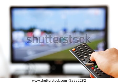 Out of focus TV LCD set and remote control in man\'s hand isolated over a white background.