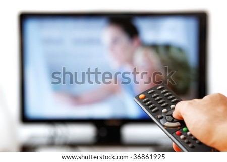 Out of focus TV LCD set and remote control in man's hand isolated over a white background.