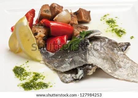 Marinated fish with vegetables on a white plate