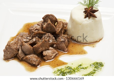Meat stew (pork or beef) with side dish on a white plate