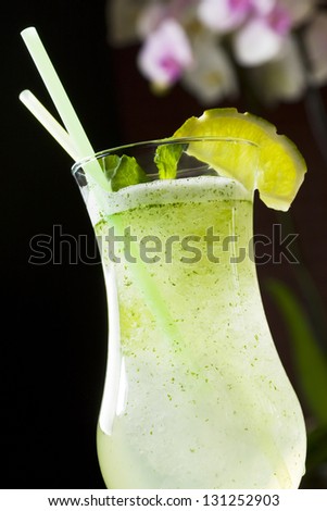 Lemonade in transparent glass over black background