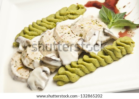 Slices of turkey dish with mashed peas as side dish