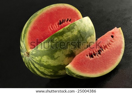 Watermelon with slice on black background