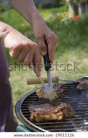 Woman preparing pork meat on a barbecue grill