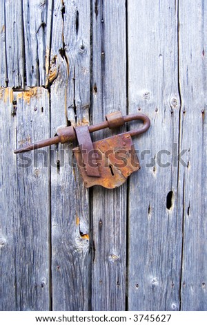 Old European padlock with old wooden background