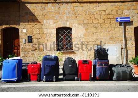 Colorful travel bags all lined up outside a boutique hotel