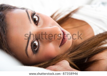 Close-up of fresh beautiful young Asian Indian model, lying down with hand in hair