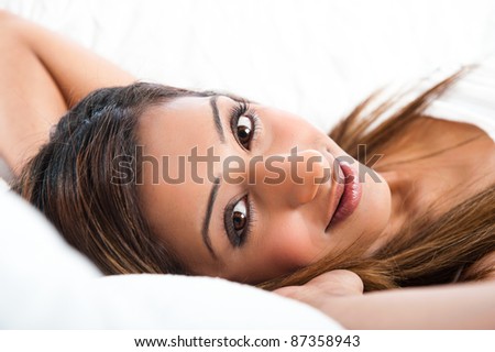 Close-up of fresh beautiful young Asian Indian model, smiling and laying down