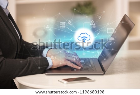 Business woman in homey environment using laptop with  online storage and cloud technology concept