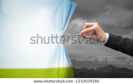 hand pulling green landscape curtain to gray landscape, environmental protection concept