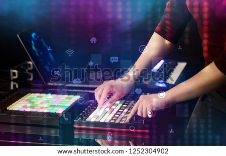Hand mixing music on dj controller with social media concept icons