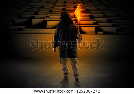 Ugly, aberrant man coming out from the labyrinth with burning flambeau on his hand