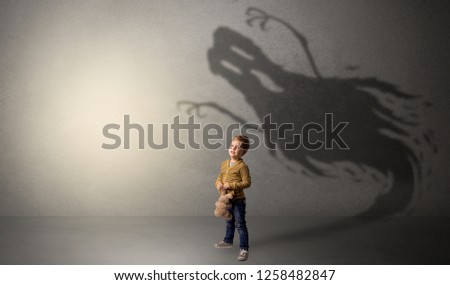 Scary ghost shadow in a dark empty room with a cute blond child