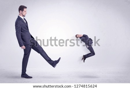 Big man in suit kicking out little himself out with simple white wallpaper