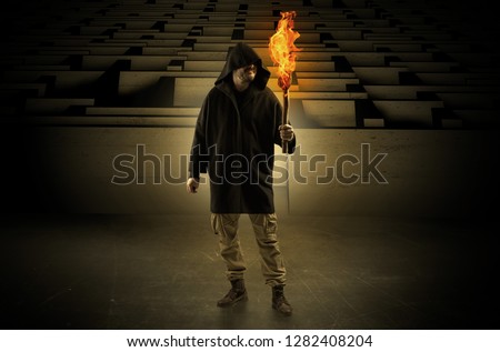 Ugly, aberrant man coming out from the labyrinth with burning flambeau on his hand