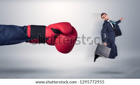 Giant hand gives a kick to a small employee businessman