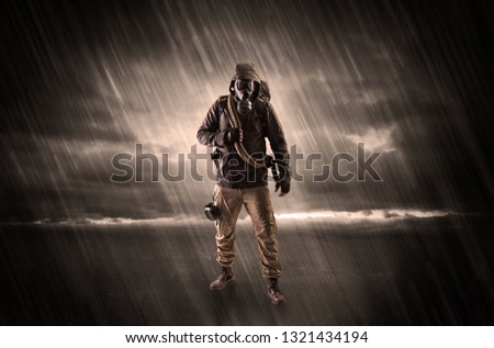 Terrorist in a stormy space with gas mask on his hand and weapons on his arm