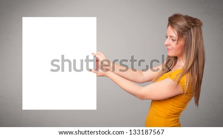 Pretty young woman presenting white paper copy space