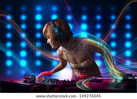 Beautiful young Dj girl mixing records with colorful lights