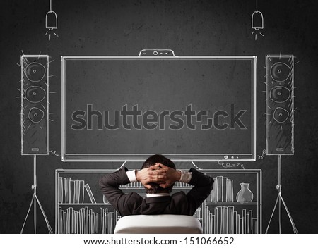 Young Businessman Sitting And Enjoying Home Cinema System Sketched On A Chalkboard