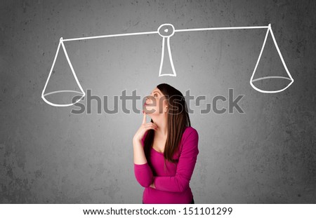 Pretty young lady taking a decision with scale above her head