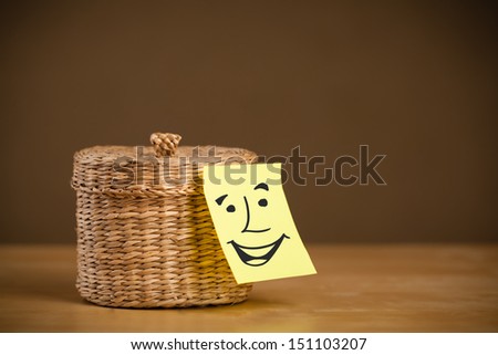 Drawn smiley face on a post-it note sticked on a jewelry box