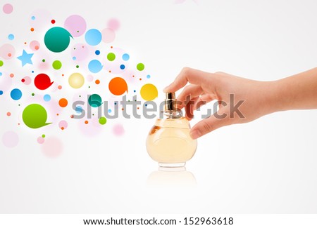 close up of woman hands spraying colorful bubbles from beautiful perfume bottle