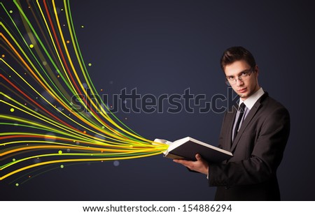 Young man reading a book while colorful lines are coming out of the book
