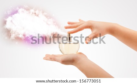 close up of woman hands spraying colorful cloud from beautiful perfume bottle