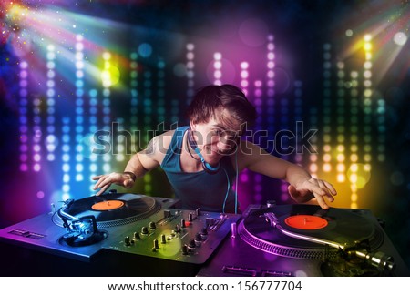 Young Dj playing songs in a disco with light show