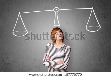Pretty young lady taking a decision with scale above her head