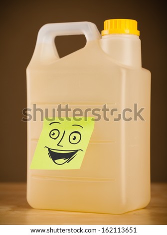 Drawn smiley face on a post-it note sticked on a gallon