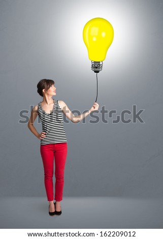 Pretty young woman holding a light bulb balloon