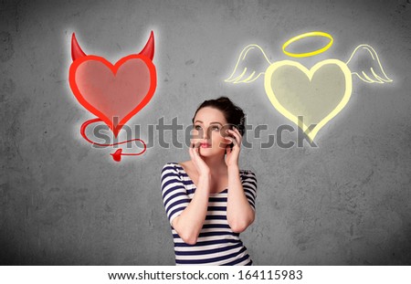 Pretty young woman standing and deciding between the angel and the devil heart